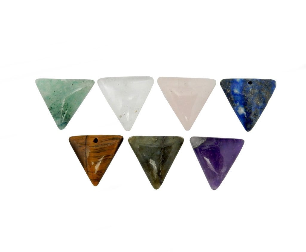 Drilled triangle beads of different crystals lined up on white background