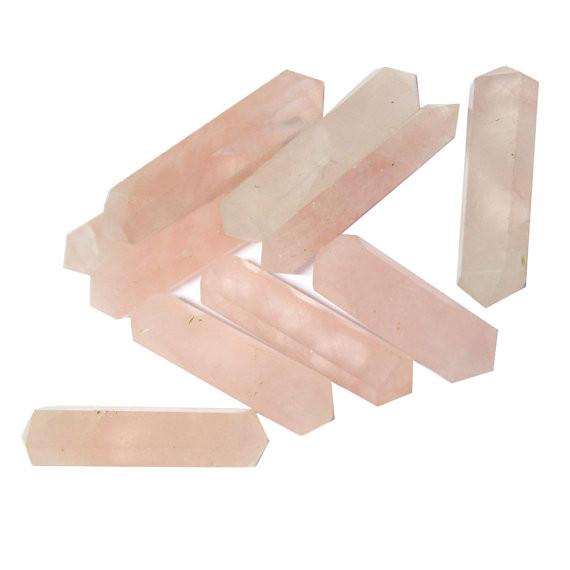Pile of Rose Quartz Double Double Terminated Pencil Points on white background