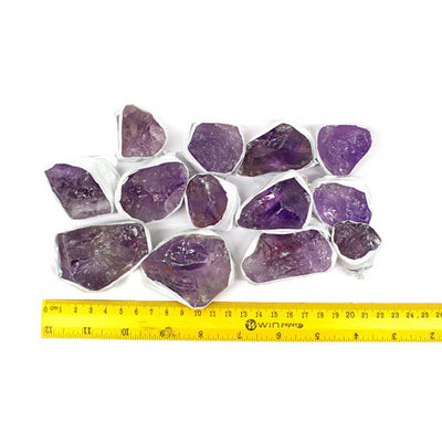 Rough Amethyst pieces next to a ruler for size reference
