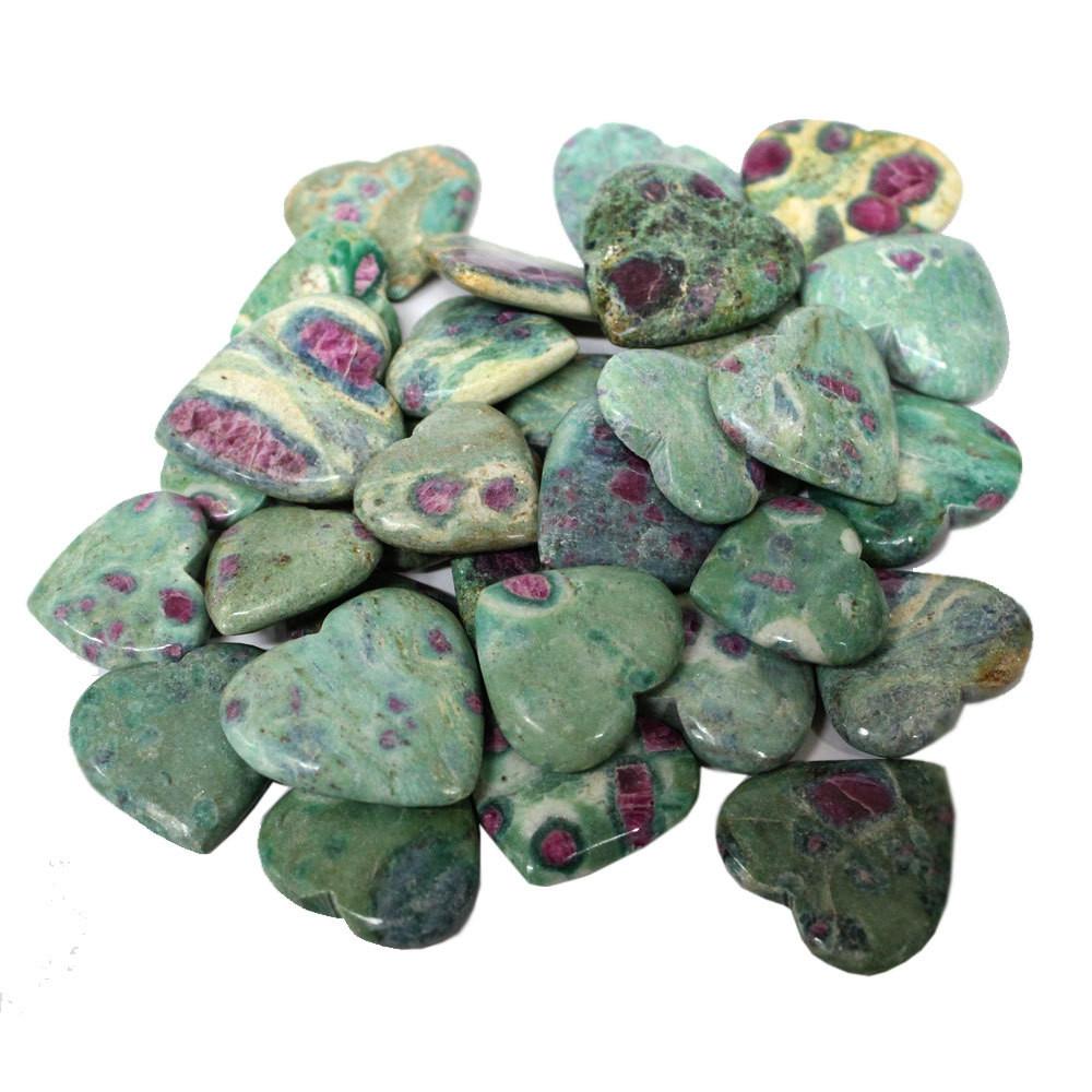 Pile of various Ruby Fuchsite Heart Shaped Stones on a white surface.