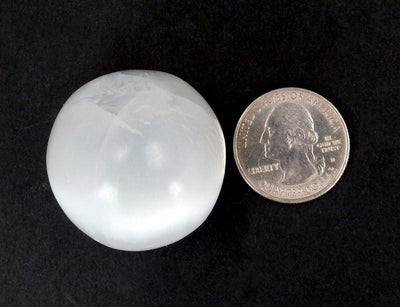 selenite sphere with quarter for approximate size reference