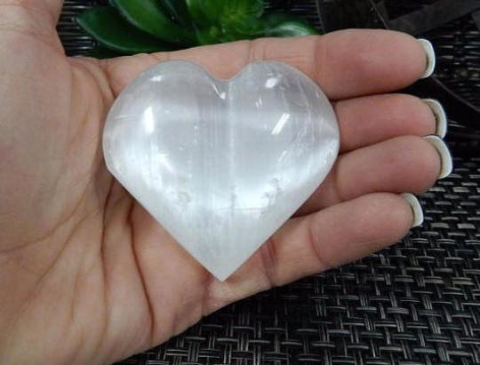 Selenite Heart Shaped Stone in a hand for size reference