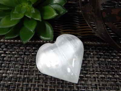 Selenite Heart Shaped Stone on a table