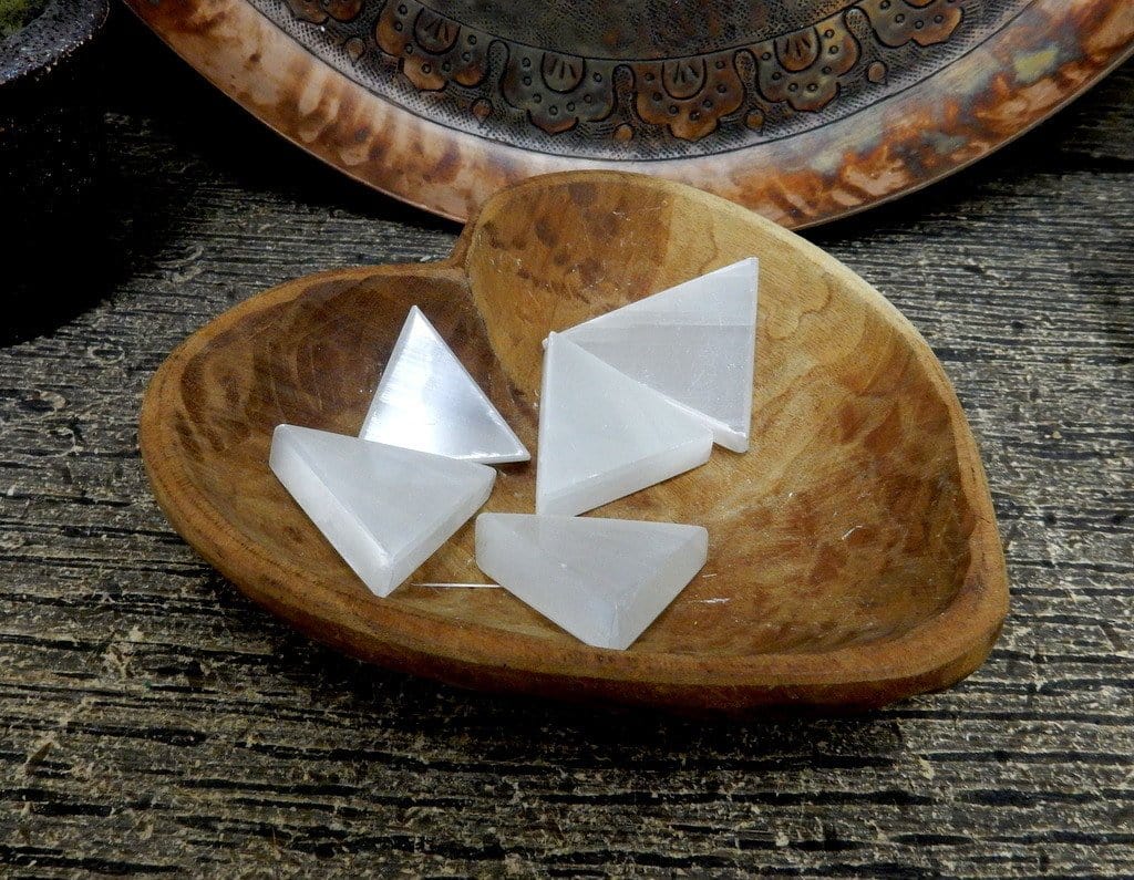 selenite triangles on display in wooden heart bowl