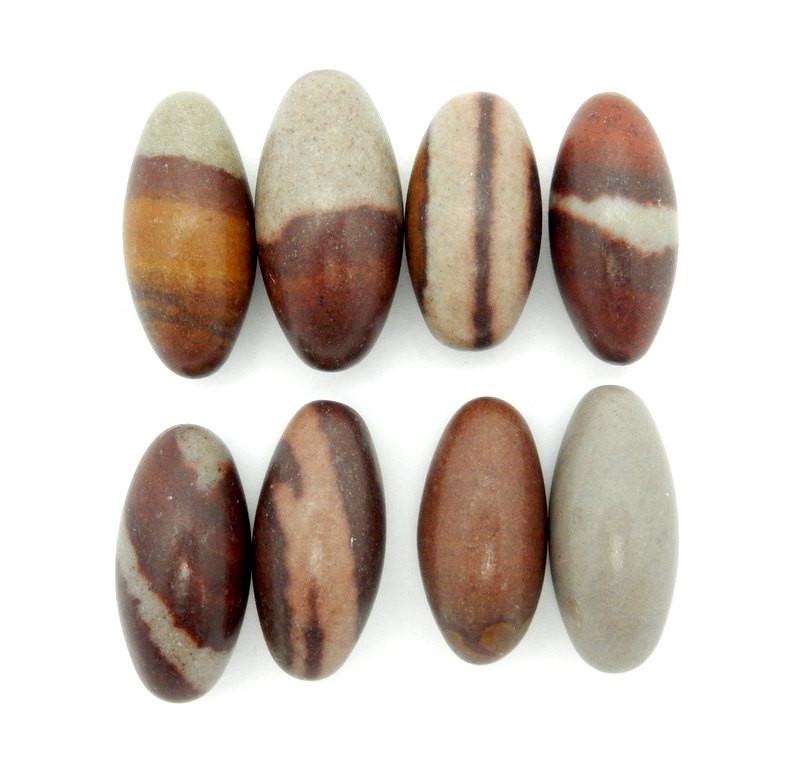 many shiva lingam stones on white background for possible variations