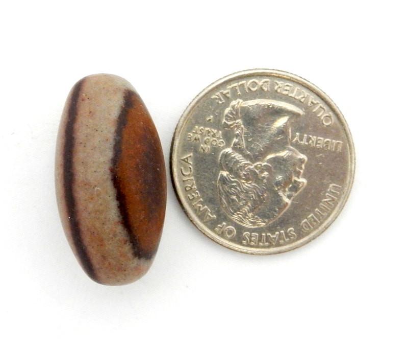 shiva lingam stone with quarter for size reference
