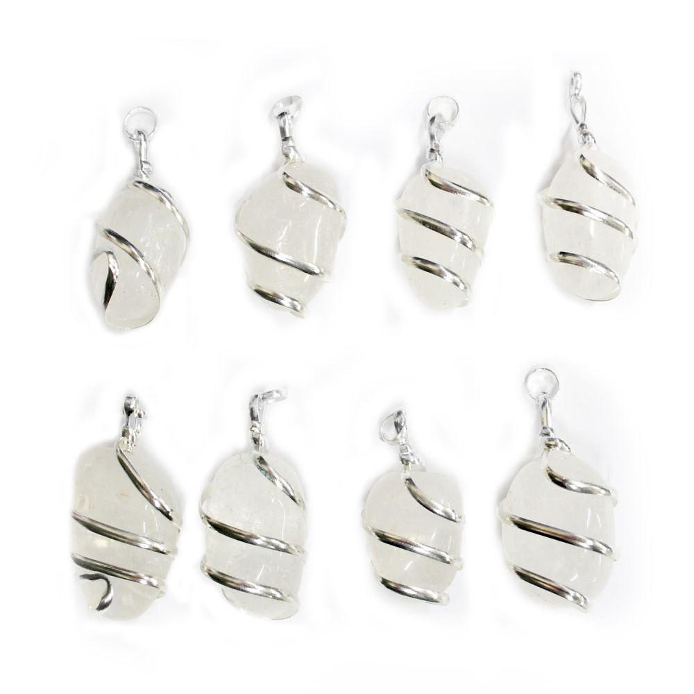 many silver spiral crystal quartz pendants in a row on white background for possible variations
