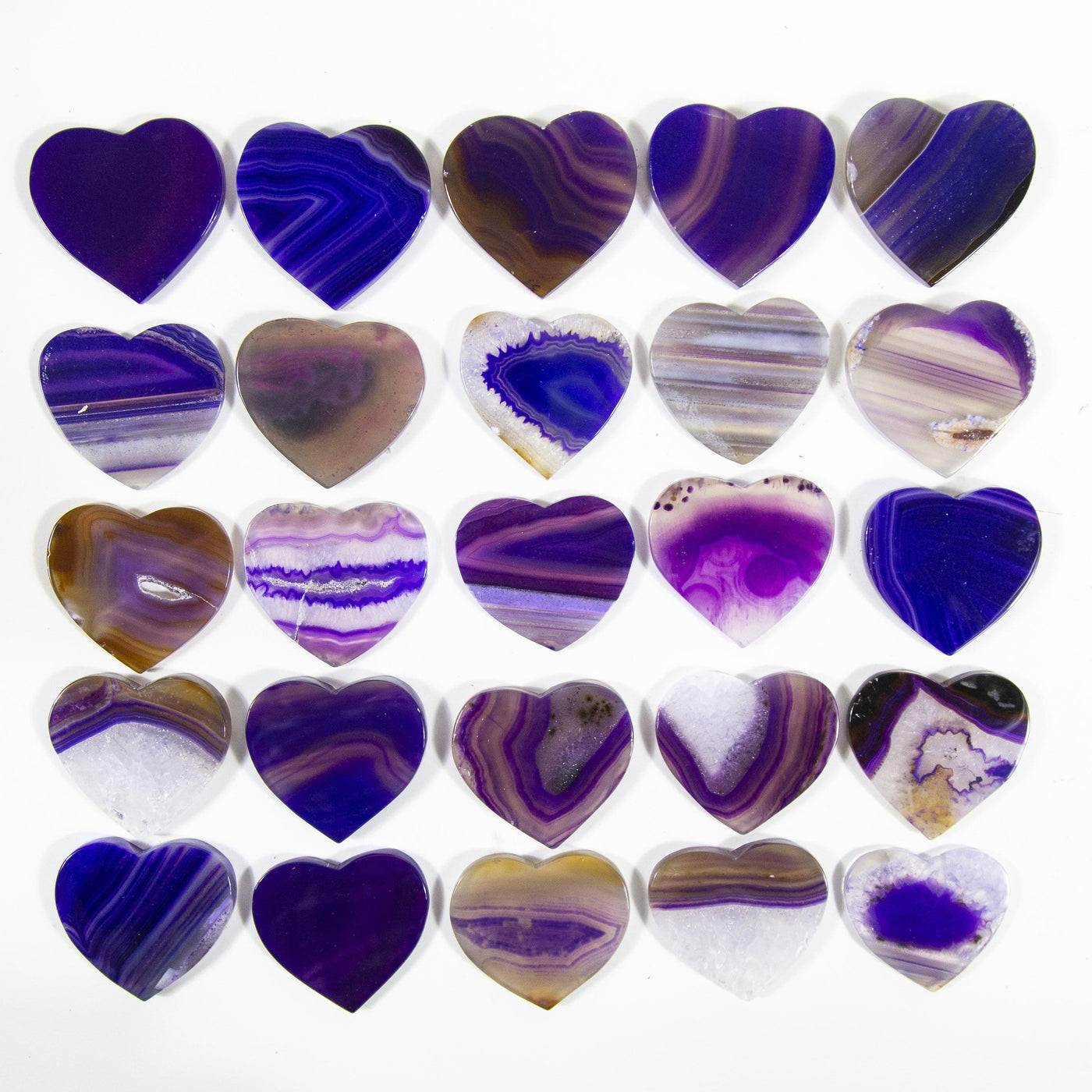 Multiple purple agate heart Shaped Cabochons displayed on a white background to display color and pattern variation.