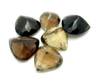 many smokey quartz beads in a pile on white background for possible variations