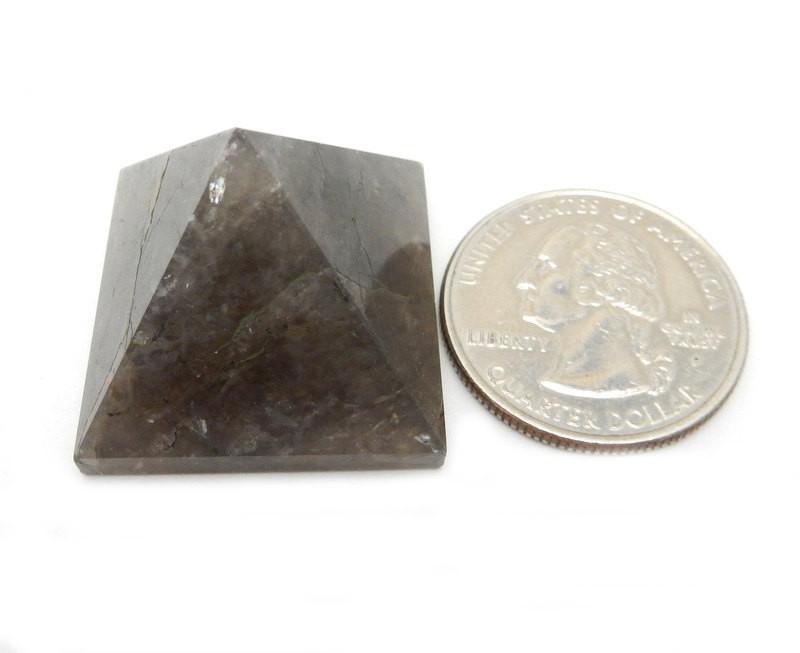 smokey quartz pyramid with quarter on white background for size reference