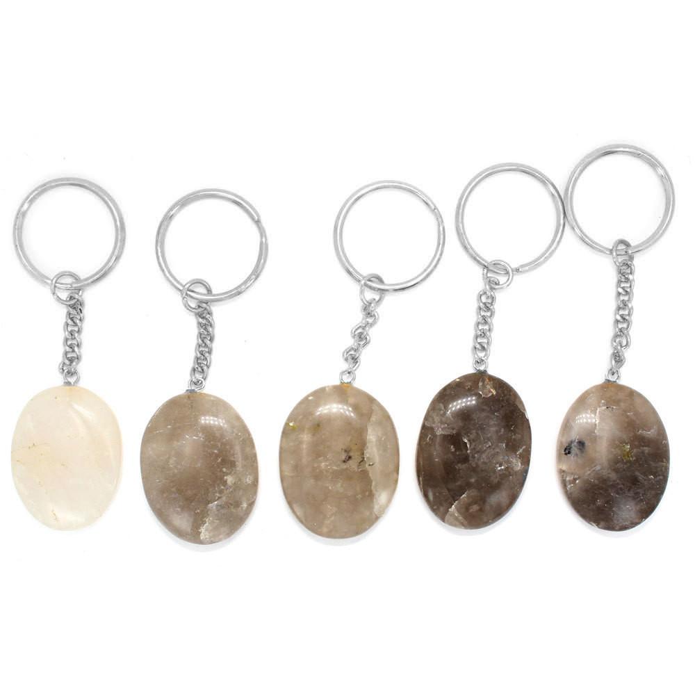 five smokey quartz worry stone keychains in a row on white background for possible variations