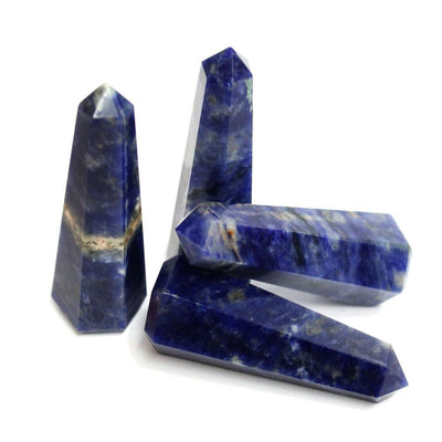 four sodalite crystal towers in a pile on white background