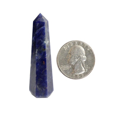 one sodalite crystal tower on white background with quarter for size reference