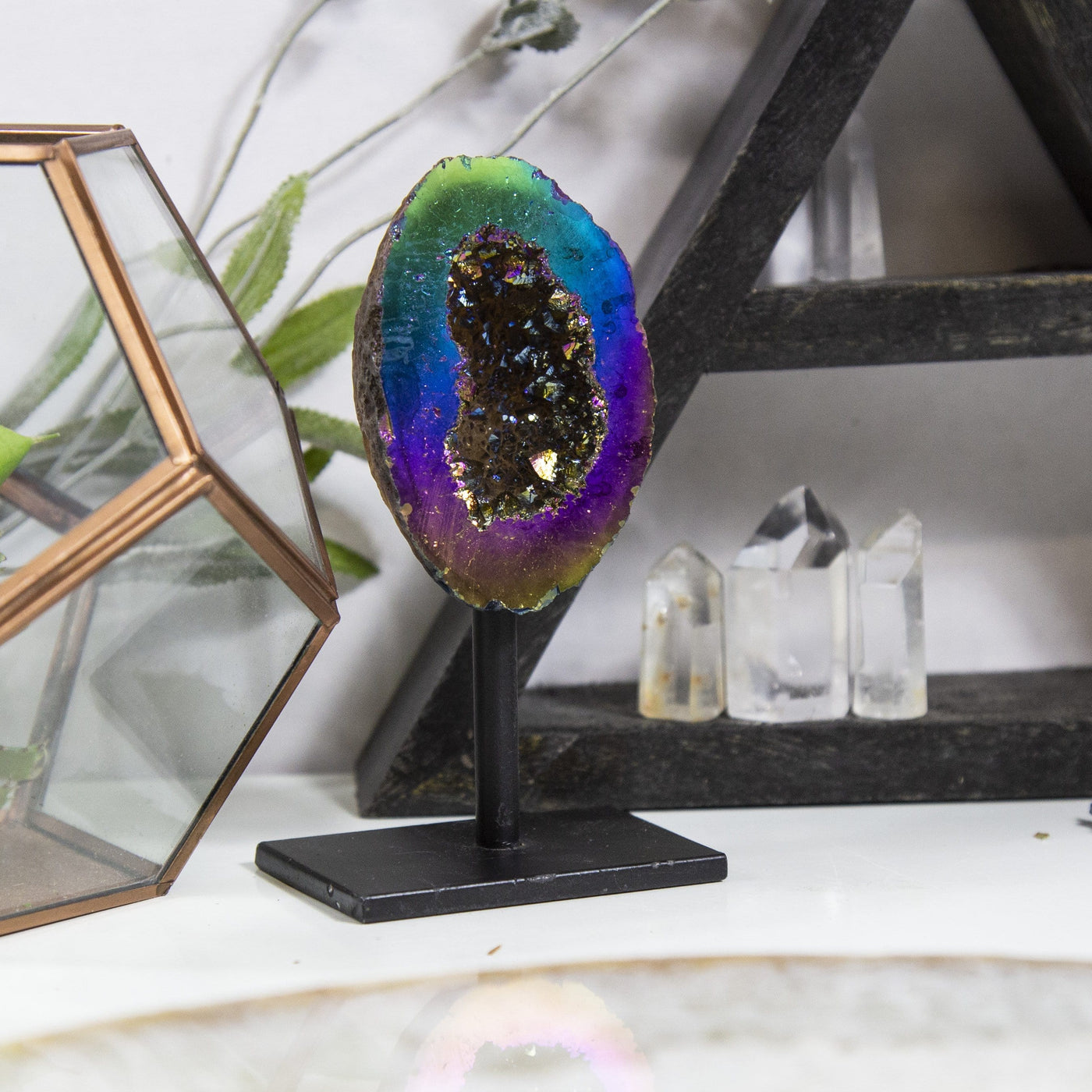 1 Rainbow Aura Geode on Stand with other crystals in the background