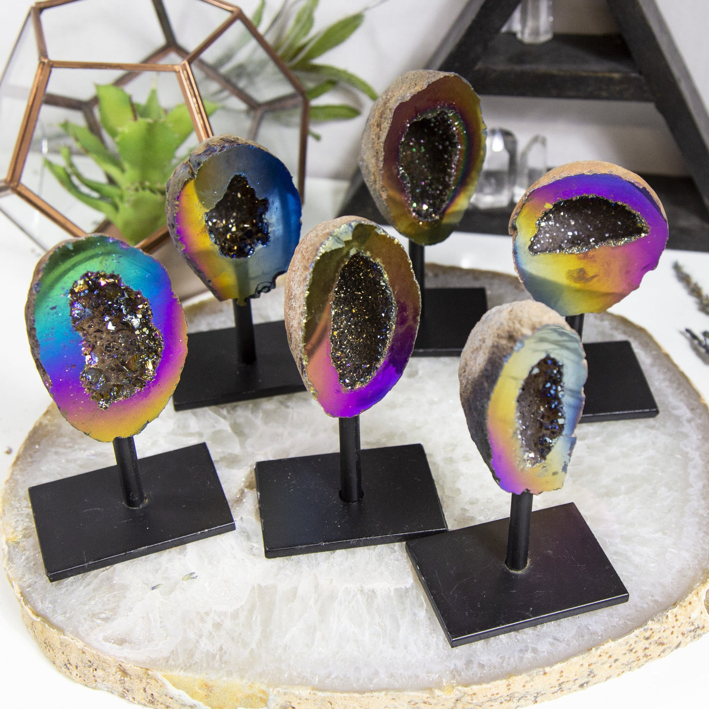 6 Rainbow Aura Geodes on Stands with various items in the background