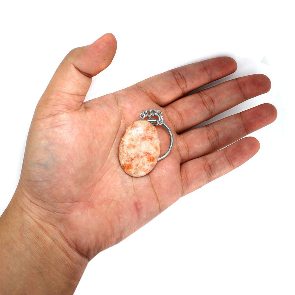 sunstone thumb stone keychain in a hand