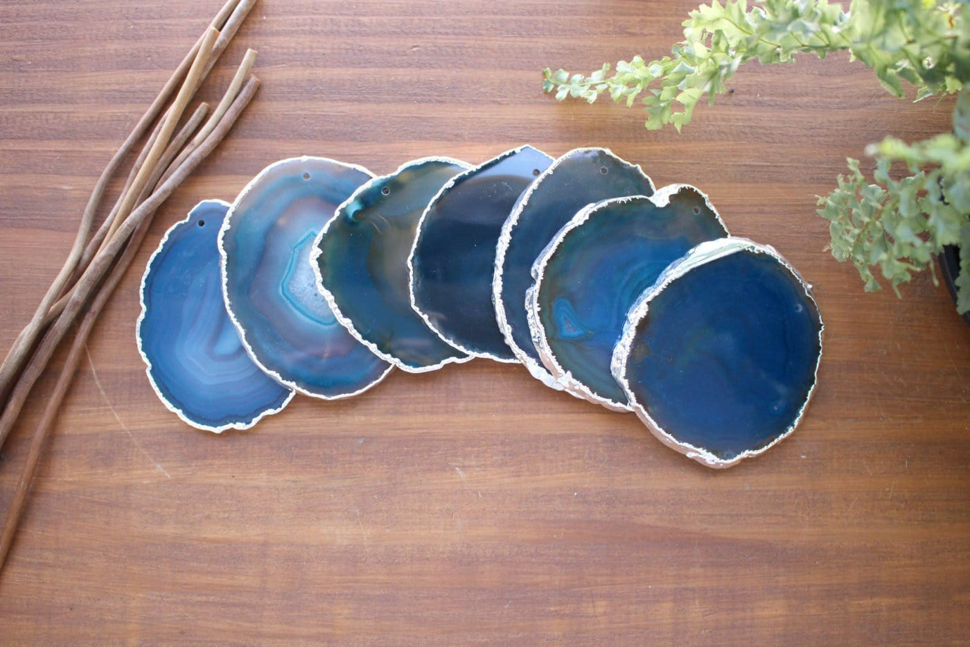 7 silver electroplated Teal Top Drilled Agate Slices layered on a table . Those agate slices measure between 3-3.5" in diameter. and have an average weight of 0.15 lb