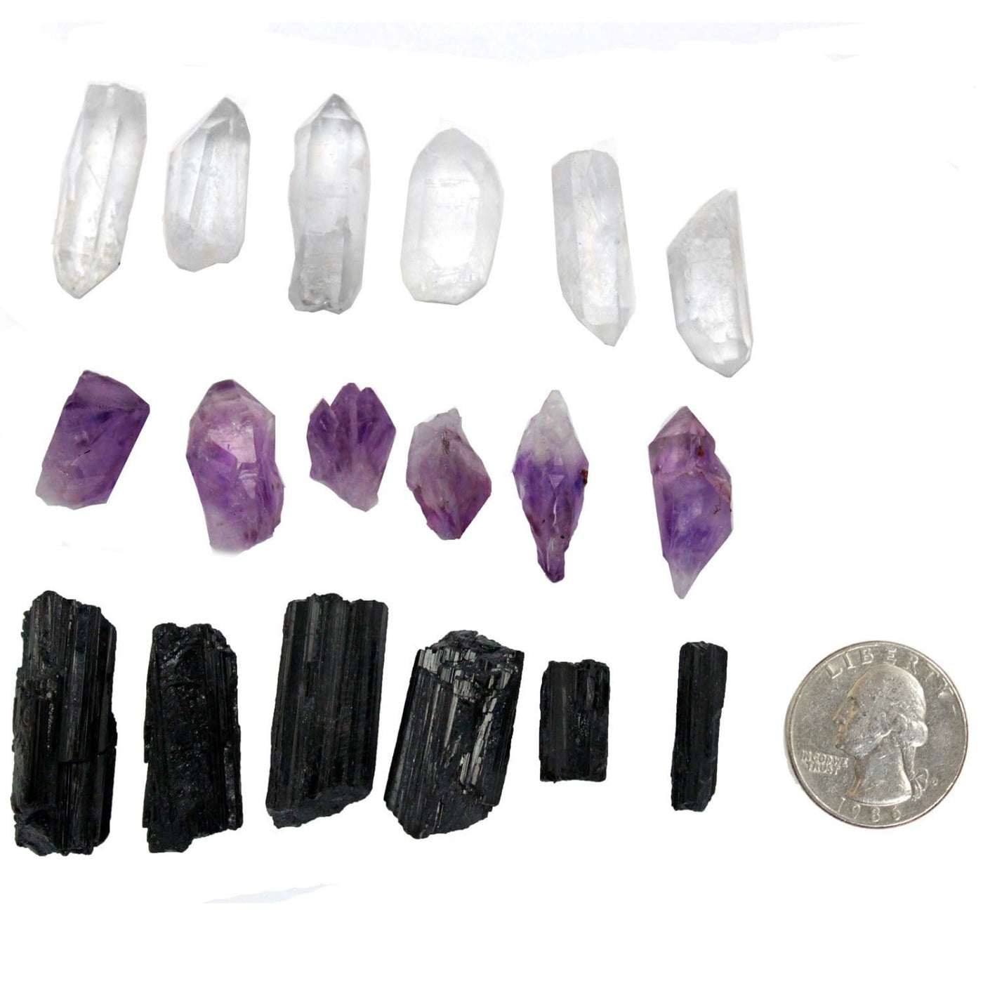 Tourmaline, Crystal Quartz, and Amethyst stones next to a quarter for sizing 