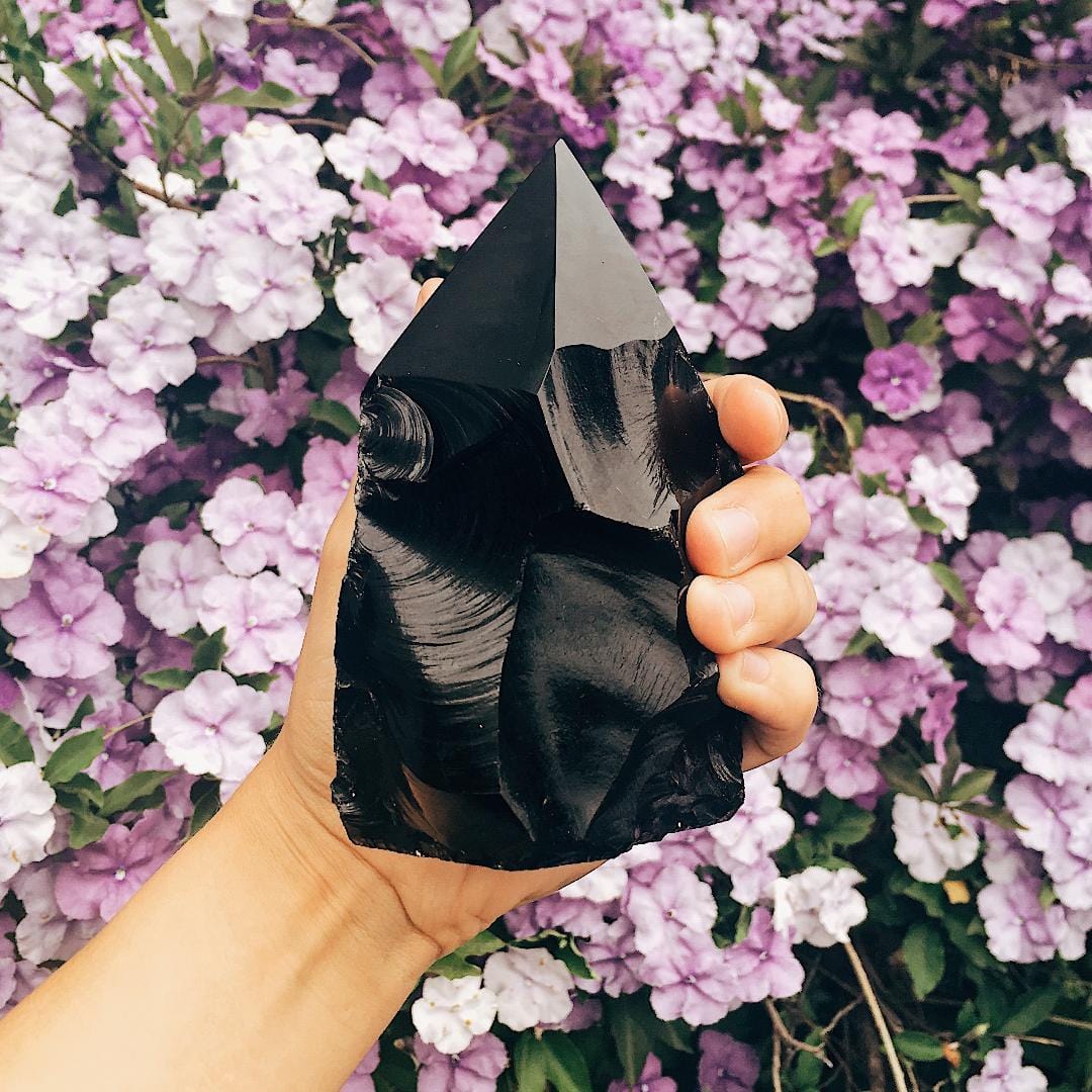 black obsidian semi polished point in hand for size reference 