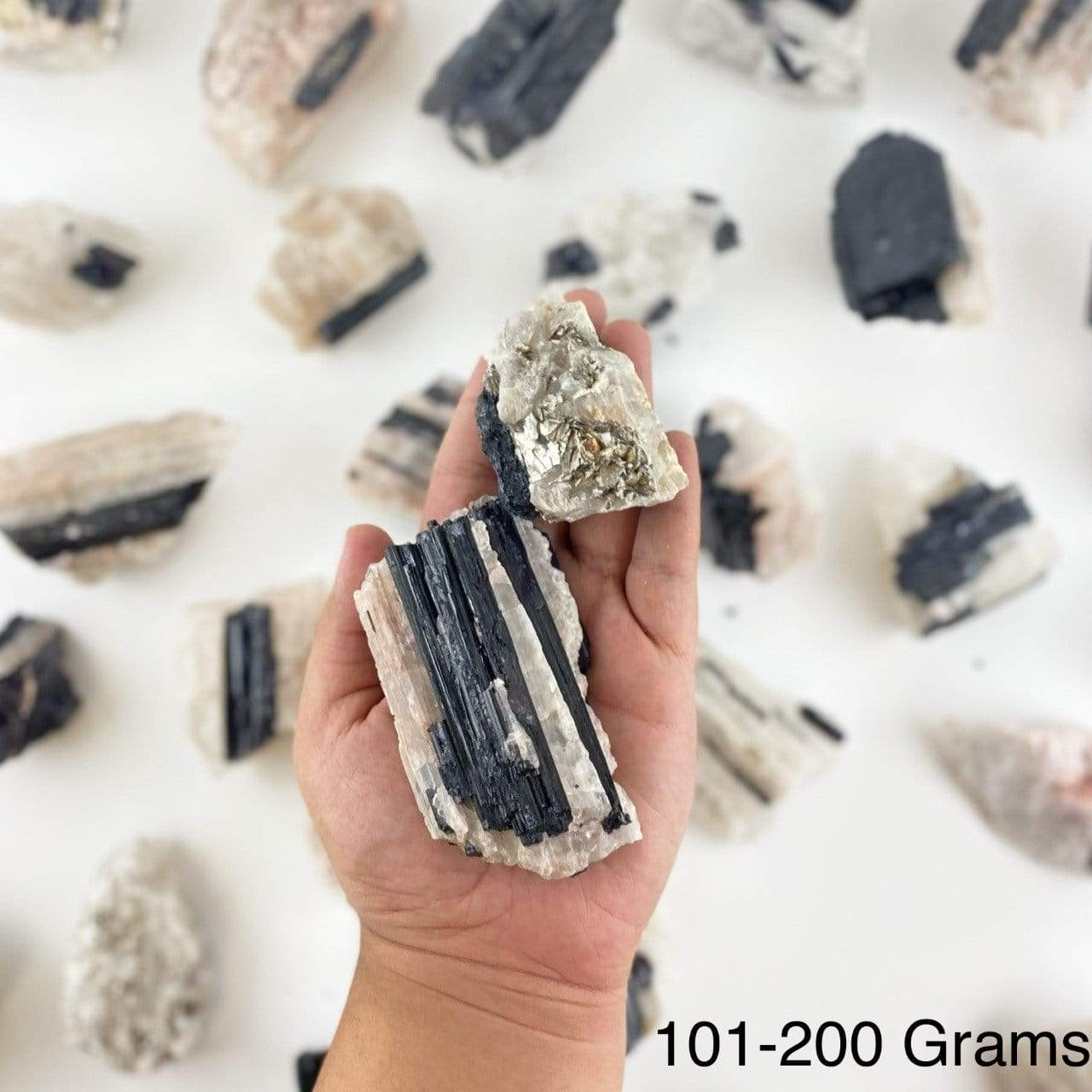 black tourmaline on matrix displayed in hand size is for 101-200 grams
