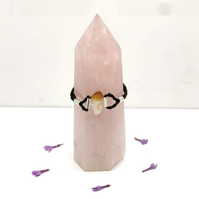 citrine leather bracelet on rose quartz point with white background