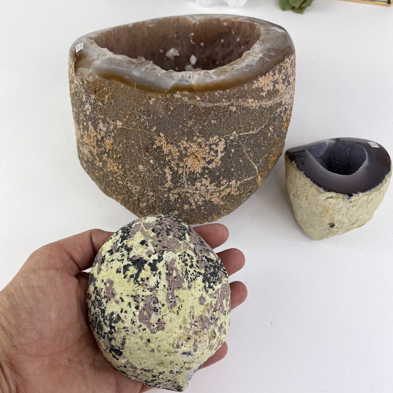 Bulk Lot 3 Polished Geode Halves with one in the hand, showing side view