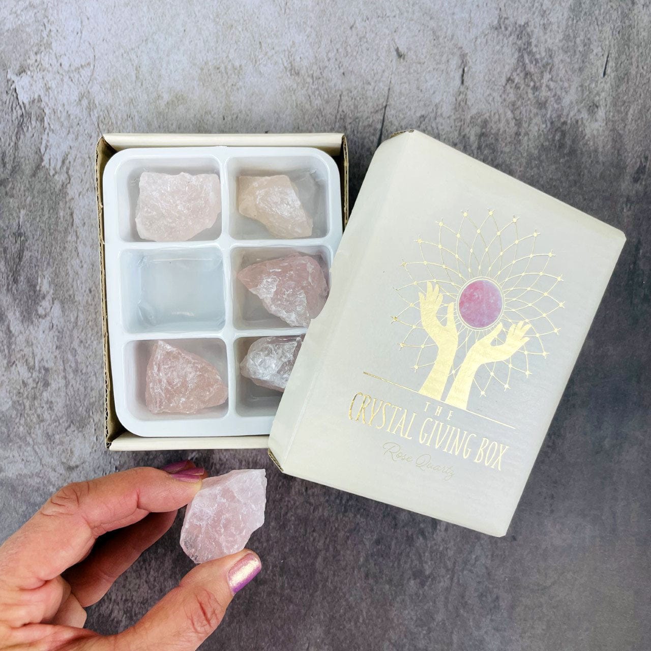 Crystal Giving Box - Set of 6 rose quartz stones with 1 stone in a hand