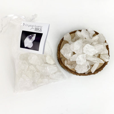 Crystal Quartz Stones - Tied & Tagged in an Organza Bag next to a pile of stones approx. 150 grams