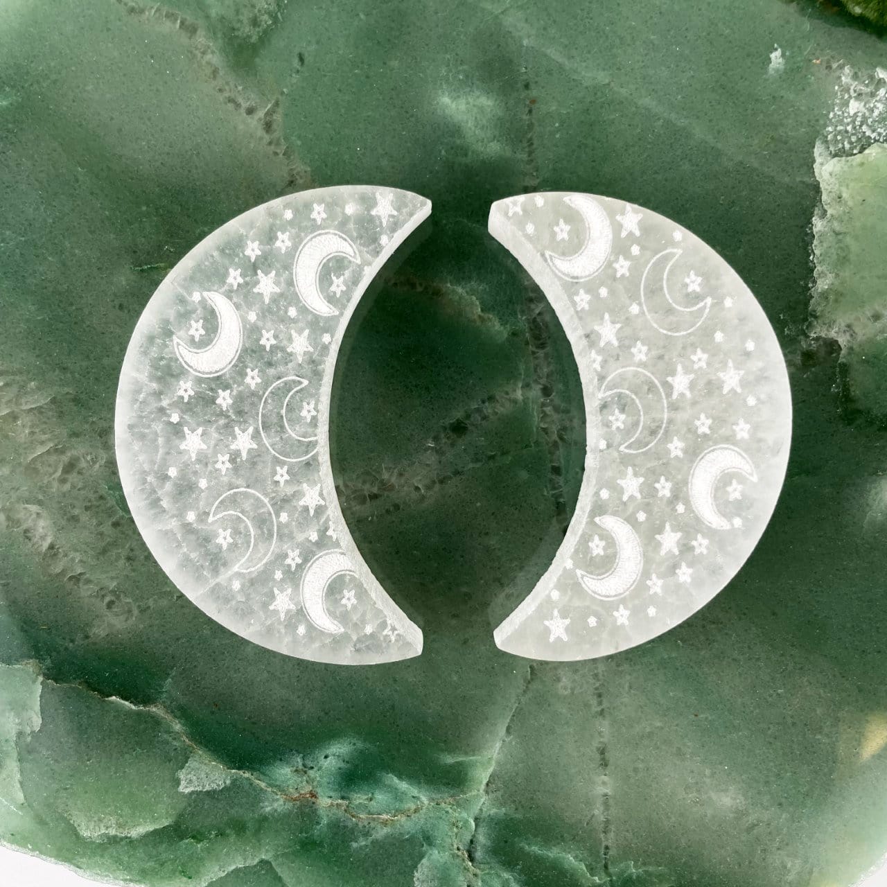 two selenite engraved crescent moon charging plates on display for engraving variations