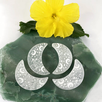 selenite engraved crescent moon charging plates on display