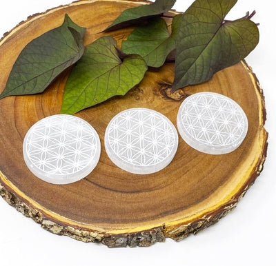 close up of three selenite round plates engraved with flower of life for engraving details and possible variations