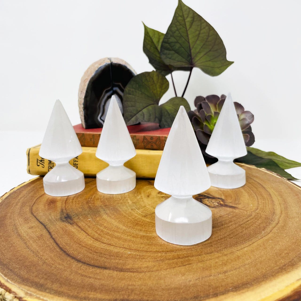 close up of one selenite round spear tip with three others in background display