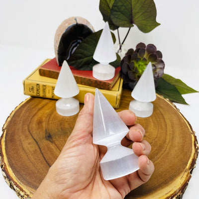 selenite round spear tip in hand for size reference with others in background display