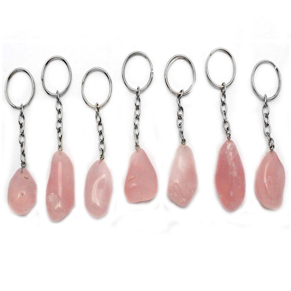 7 tumbled rose quartz keychains on white background