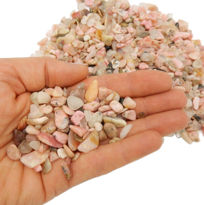 pink opal small tumbled stones in hand for size reference 