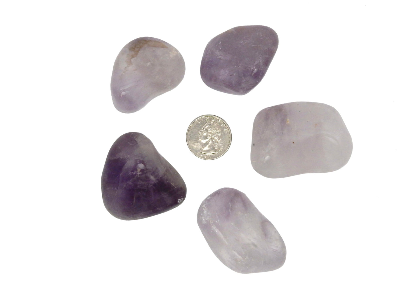 tumbled amethyst surrounding a quarter for size reference