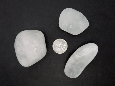 crystal tumbled stones around a quarter