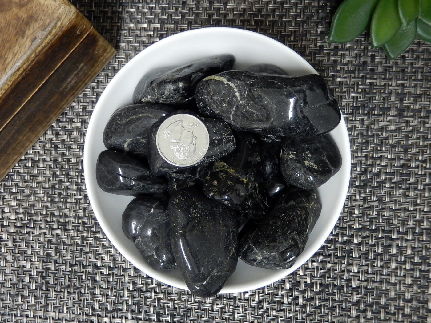 Natural Large Black Tourmaline Tumbled - a bunch in a bowl with a quarter in the middle