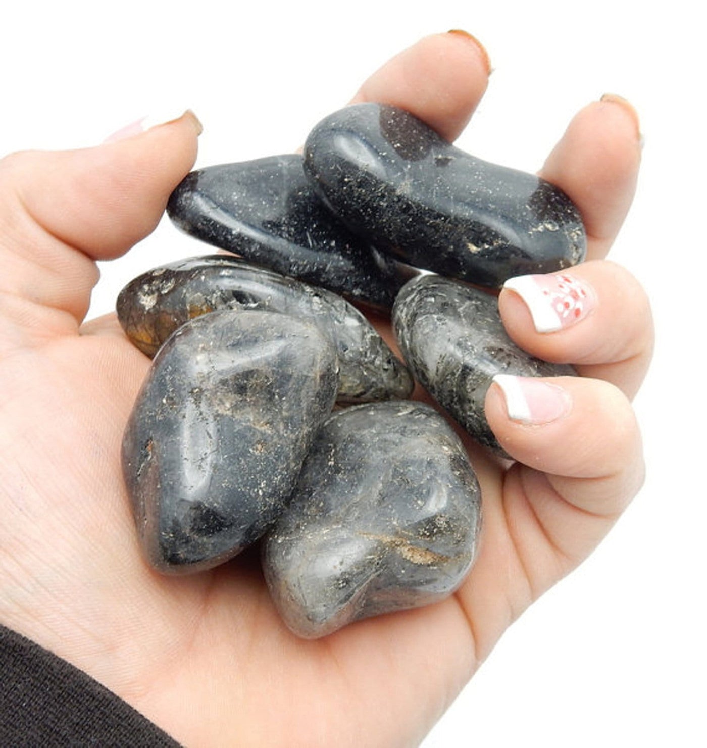 tumbled rutilated stones in a hand