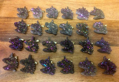 20 Rainbow Titanium Druzy Unicorn Pendants with gold bails lined up on wooden table