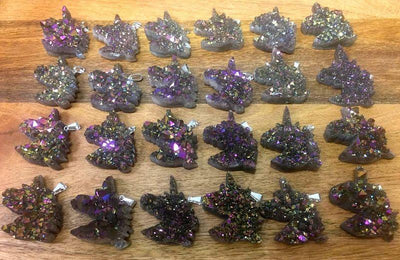 20 Rainbow Titanium Druzy Unicorn Pendants with silver bails lined up on wooden table