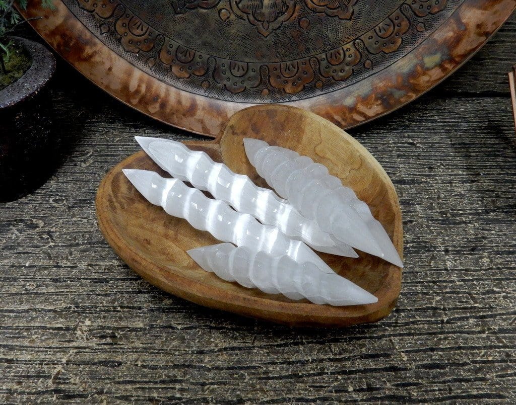 4 spiral shaped selenite massage wands in a wooden heart bowl with decorations