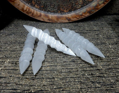 5 spiral selenite massage wands with decorations in the background