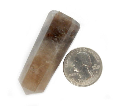 one smokey quartz drilled point on white background with quarter for size reference