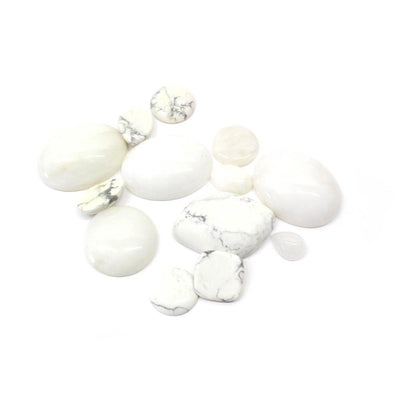side view of multiple mixed shape white howlite cabochons for thickness reference