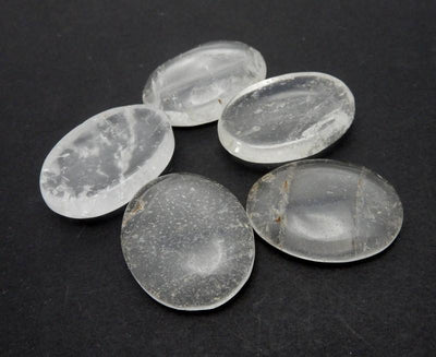 Close uo view of Crystal Quartz Worry Stone Slab on a black background