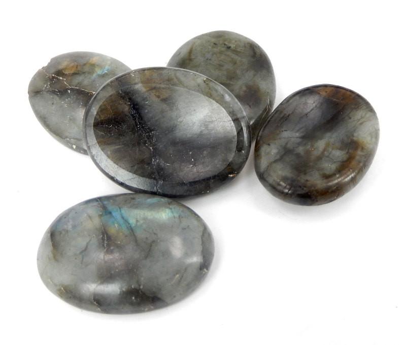 multiple labradorite thumb stones displayed to view various characteristics on white background