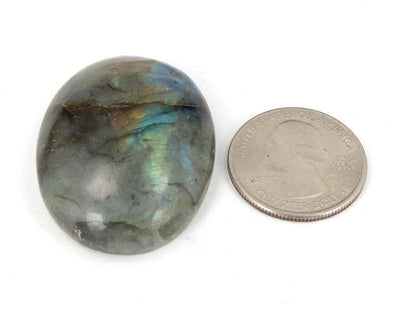 labradorite thumb stone displayed next to quarter for size reference