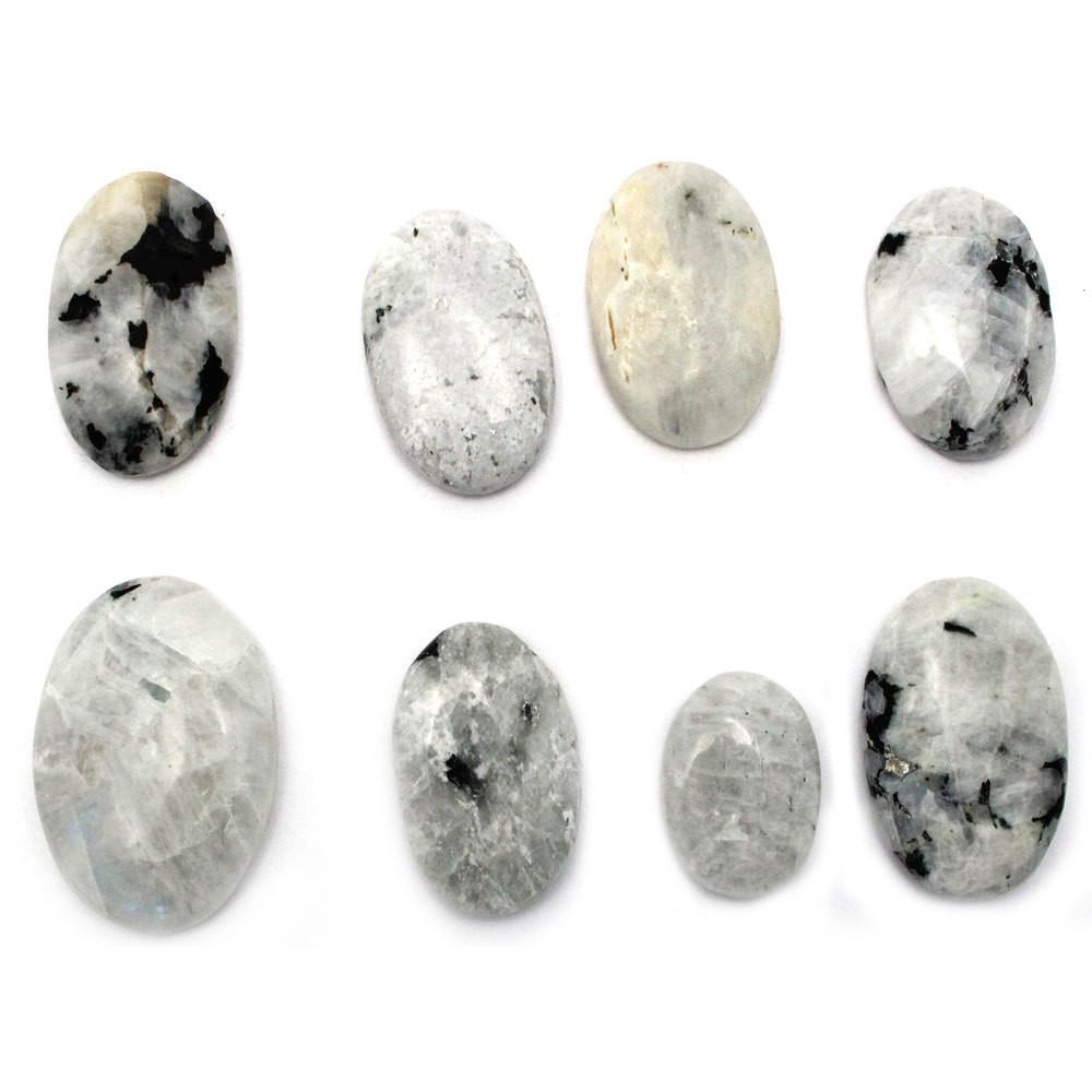 8 moonstone worry stones on a white background.  They are all different patterns of white cream gray and black and sizes can vary.