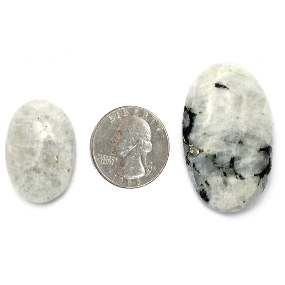 two moonstone worry stones with a quarter between them on a white background.  They are larger than the quarter but size does vary.
